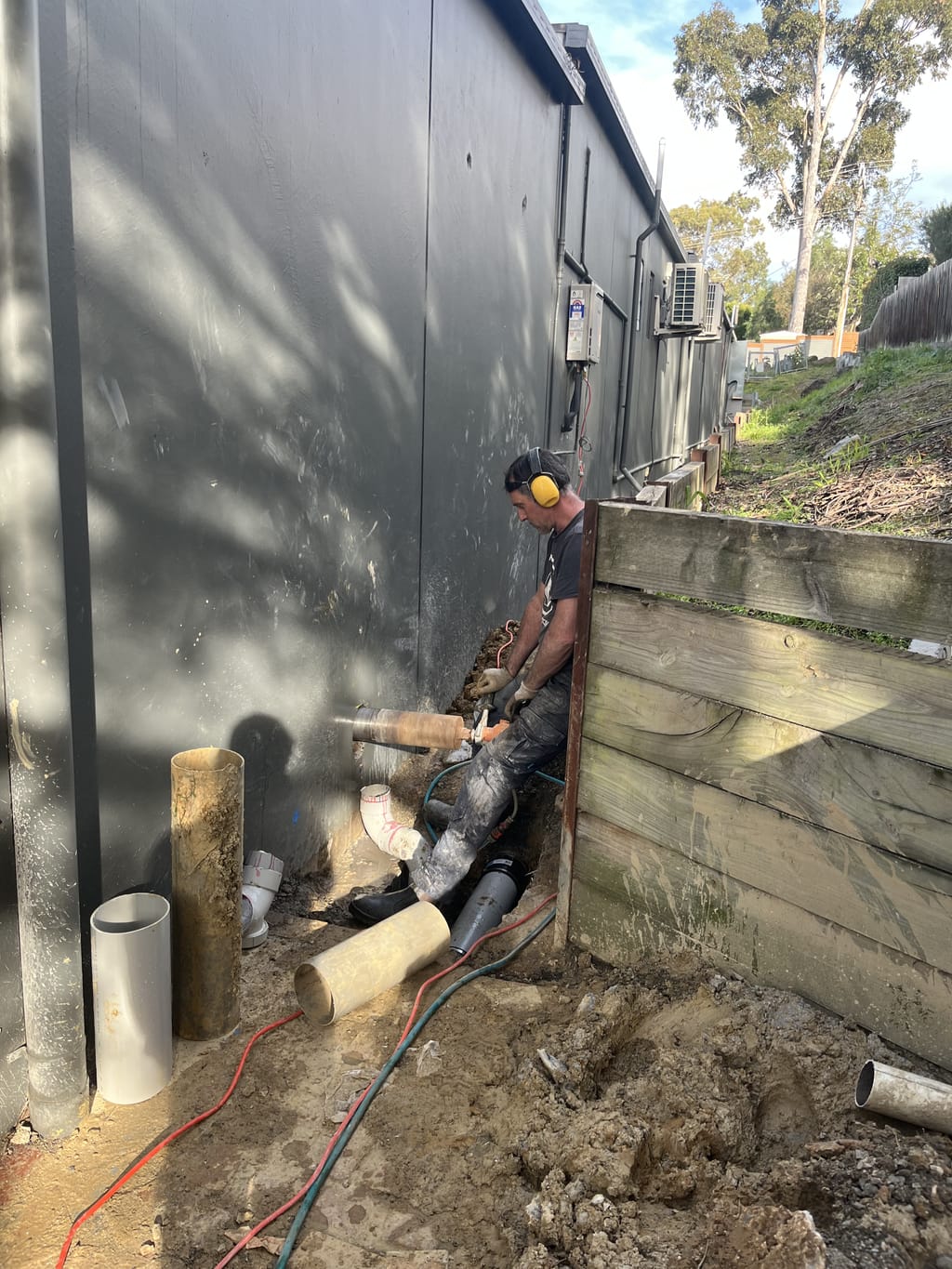 Frazzetto operator core drilling a large penetration through a concrete wall